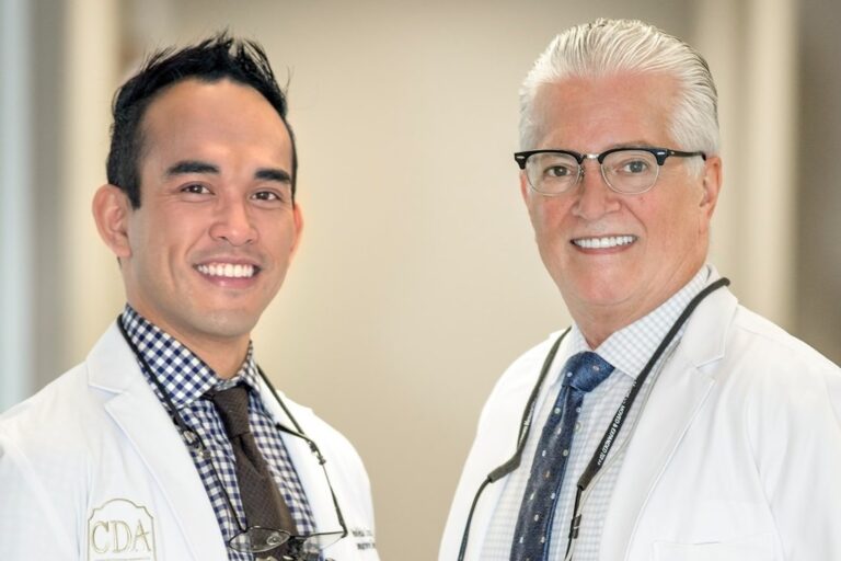 Dr. Landry + Dr. Cruz smiling in the office